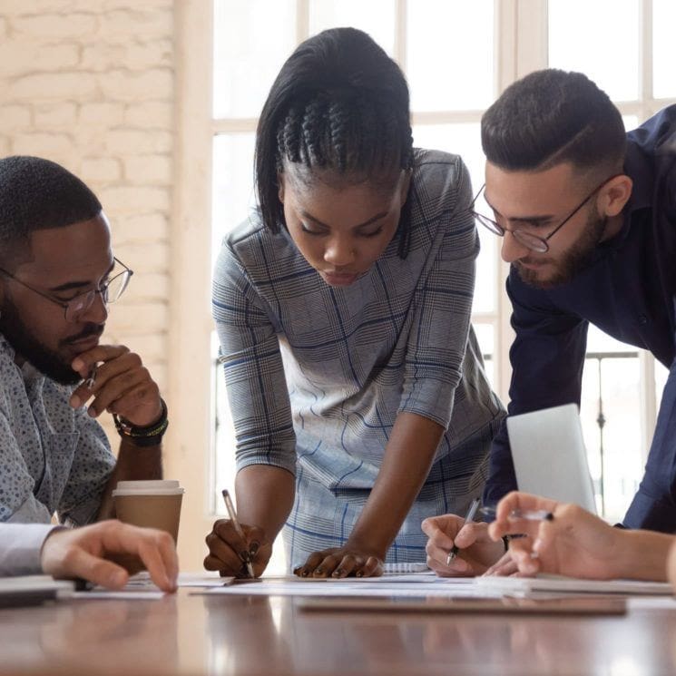 woman writing a document while men watch