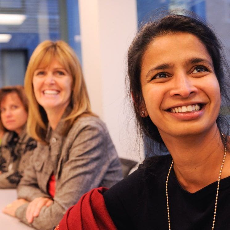 women at an event smiling