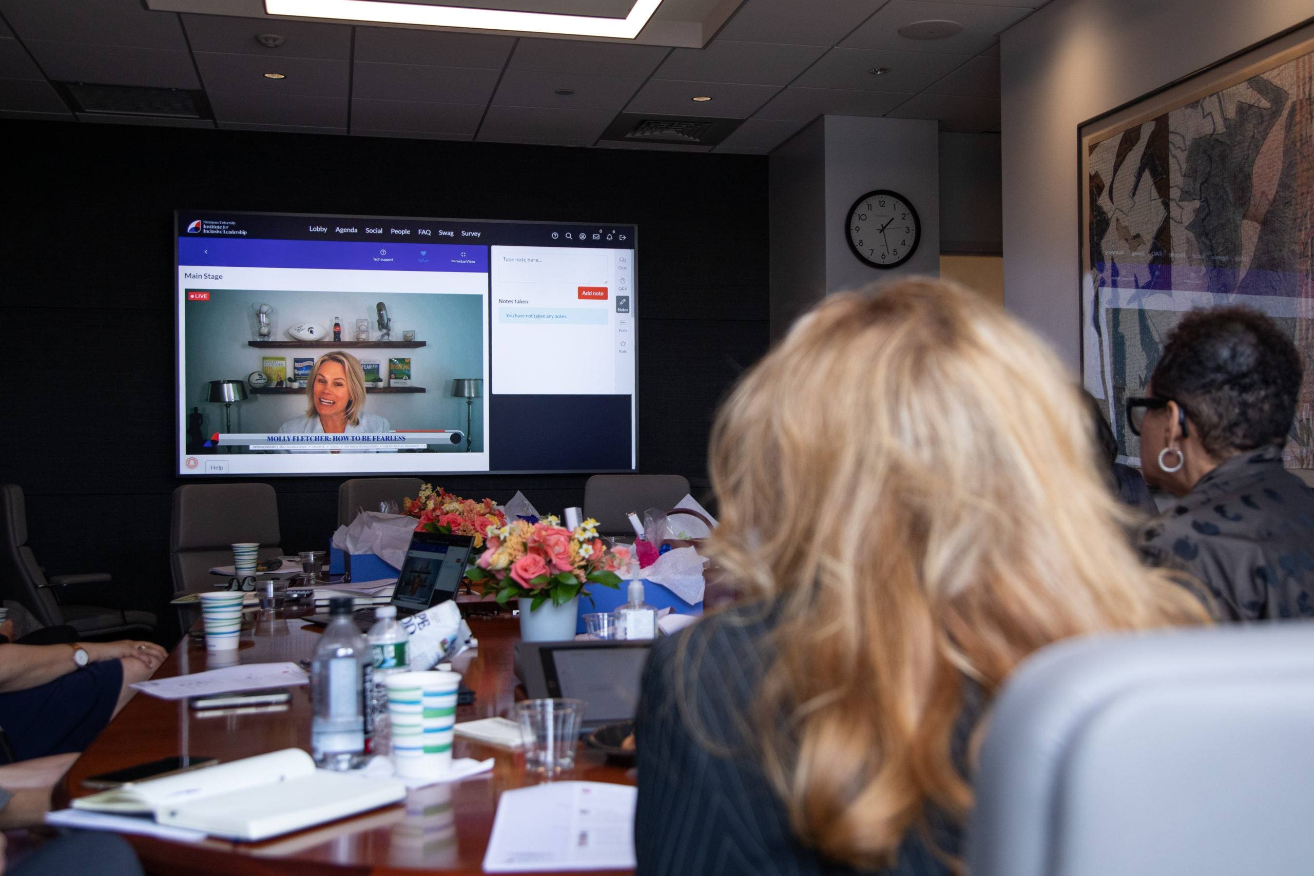 people in conference room watching large screen