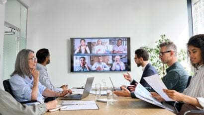 professionals in a conference room doing a zoom call