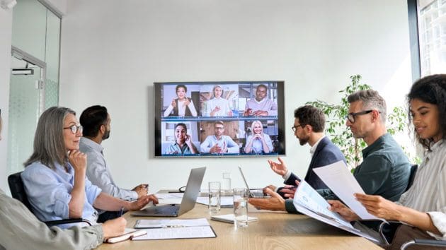 professionals in a conference room doing a zoom call