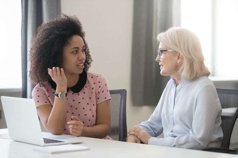 older woman mentoring younger woman in an office
