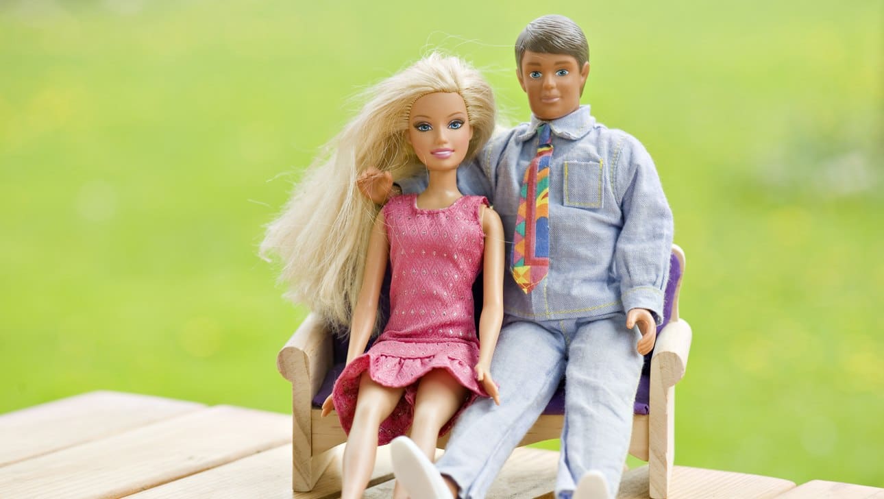 ken and barbie dolls sitting in a chair