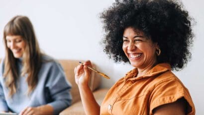 two women smiling sitting in a room